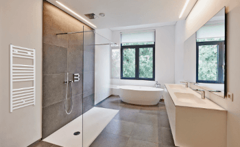 Towel warmer installed on a bathroom wall next to the shower for easy access